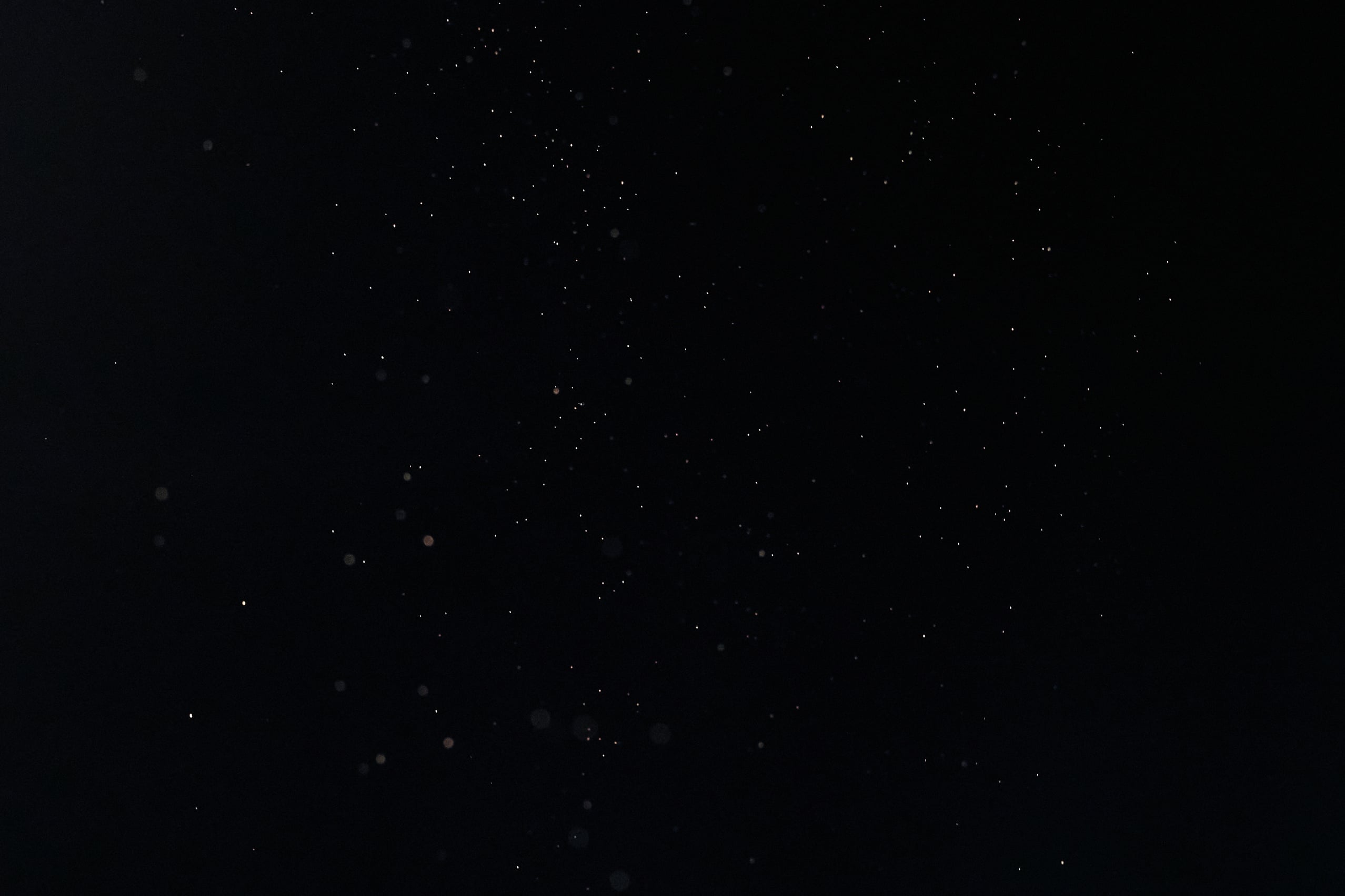 Tiny White Dust Particles on Black Background